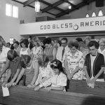 
              FILE - Chowchilla church-goers give a prayer of thanks for the safe return of their 26 school children and bus driver, during a service at the Chowchilla Baptist Church, in Chowchilla, Calif., July 18, 1976. California parole commissioners have recommended parole for the last of three men convicted of hijacking a school bus full of children for $5 million ransom in 1976. The two commissioners acted Friday, March 25, 2022, in the case of 70-year-old Frederick Woods. All three were from wealthy San Francisco Bay Area families when they kidnapped 26 children and their bus driver near Chowchilla. (AP Photo/Jim Palmer, File)
            