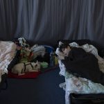 
              People who fled the war in Ukraine rest inside an indoor sports stadium of a high school in Przemysl, southeastern Poland, on Friday March 18, 2022. (AP Photo/Petros Giannakouris)
            