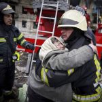 
              In this photo released by Ukrainian State Emergency Service, a firefighter hugs an elderly woman after evacuation from an apartment building hit by shelling in Kyiv, Ukraine, Monday, March 14, 2022. (Ukrainian State Emergency Service via AP)
            