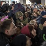 
              A Ukrainian soldier tries to disperse the crowd as they push to enter a train to Lviv at the Kyiv station, Ukraine, Friday, March 4. 2022. Ukrainian men have to stay to fight in the war while women and children are leaving the country to seek refuge in a neighboring country. (AP Photo/Emilio Morenatti)
            