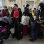 
              Refugees with children wait for a transport after fleeing the war from neighbouring Ukraine at a railway station in Przemysl, Poland, on Tuesday, March 22, 2022. (AP Photo/Sergei Grits)
            