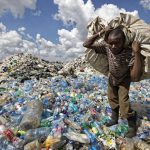 
              FILE - A man walks on a mountain of plastic bottles as he carries a sack of them to be sold for recycling after weighing them at the dump in the Dandora slum of Nairobi, Kenya on Dec. 5, 2018. The U.N. Environment Assembly (UNEA) unanimously voted Wednesday, March 2, 2022 in Nairobi, Kenya to start to create a legally binding global treaty to address plastic pollution in the world's oceans, rivers and landscape. (AP Photo/Ben Curtis, File)
            