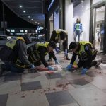 
              Members of Israeli ZAKA emergency and response team clean the blood stains at the scene of an attack in Beersheba, southern Israel, Tuesday, March 22, 2022. A knife-wielding Arab man killed several people and seriously wounded others in the southern Israeli city of Beersheba, a rampage officials called a terror attack with nationalist motives. (AP Photo/Tsafrir Abayov)
            