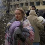 
              FILE - Mariana Vishegirskaya stands outside a maternity hospital that was damaged by shelling in Mariupol, Ukraine, March 9, 2022. Vishegirskaya survived the shelling and later gave birth to a girl in another hospital in Mariupol. (AP Photo/Mstyslav Chernov, File)
            