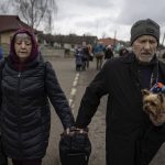 
              An elderly couple walk along the road between Lviv and Shehyni, in Volytsya, Ukraine, Saturday March 5, 2022. The number of Ukrainians forced from their country since the Russian invasion has been increasing on a daily basis. (AP Photo/Marc Sanye)
            