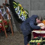 
              A relative mourns on the coffin with the body of 3 year-old Mykola Goryainiv, who died with his parents as they were driving a car trying to evacuate from a fighting zone in Kharkiv region, during a funeral ceremony in Kramatorsk, Ukraine, Wednesday, March 30, 2022. (AP Photo/Andriy Andriyenko)
            