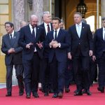 
              French President Emmanuel Macron, center, speaks with European Council President Charles Michel, center left, as they walk to a group photo at an EU summit at the Chateau de Versailles, in Versailles, west of Paris, Thursday, March 10, 2022. European Union leaders on Thursday will focus on how to help Ukraine in its war with Russia, but the measures discussed are expected to stop short of fulfilling the country's hopes it can soon join the bloc. (AP Photo/Michel Euler)
            