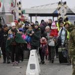 
              People carry their belongings at the Ukrainian-Polish border crossing in Korczowa, Poland, Saturday, March 5, 2022. (Olivier Douliery, Pool Photo via AP)
            