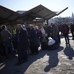 
              People wait in a line to board a train leaving for Lviv in Ukraine at the train station in Przemysl, Poland, Monday, March 14, 2022. While tens of thousands of people have fled Ukraine every day since Russia's invasion, a small but growing number are heading in the other direction. At first they were foreign volunteers, Ukrainian expatriate men heading to fight and people delivering aid. But increasingly, women are also heading back. (AP Photo/Daniel Cole)
            