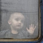 
              FILE - A child watches from a train carriage, waiting to leave to western Ukraine at the railway station in Kramatorsk, eastern Ukraine, Sunday, Feb. 27, 2022. The United Nations says that more than 3.6 million people have fled Ukraine since the war started exactly one month ago Thursday in what is the biggest movement of people in Europe since World War II. Unprepared, most refugees believed they would soon be back home. That hope is waning now. (AP Photo/Andriy Andriyenko, File)
            