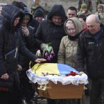 
              Relatives and friends react near the coffin of Ukrainian servicemen Oleksiy Lunyov in Yuzhne, Odessa region, Ukraine, Sunday, March 27, 2022. Lunyov was killed during a Russian missile attack in Mykolaiv on March 18. (AP Photo/Max Pshybyshevsky)
            