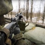 
              In this photo taken from video released by the Russian Defense Ministry Press Service on Thursday, March 3, 2022, a Russian soldier points a gun from a Russian military truck as it drives through an undisclosed location in Ukraine. (Russian Defense Ministry Press Service via AP)
            