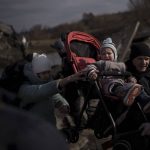 
              A child is carried on a stroller across an improvised path while fleeing Irpin, on the outskirts of Kyiv, Ukraine, Wednesday, March 9, 2022. (AP Photo/Felipe Dana)
            