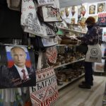 
              A photo of Russian President Putin signed "From Russia with love" is seen on a package of T-shirt in a souvenir shop in Sofia , Thursday, March 17, 2022. Russian items will be removed from the shop after the war in Ukraine. escalated, says the souvenir shop seller. (AP Photo/Valentina Petrova)
            