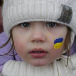 
              Zlata, 3 and half year-old, fleeing the conflict from neighbouring Ukraine with her face painted in the colours of the Ukrainian flag stands at the Romanian-Ukrainian border, in Siret, Romania, Thursday, March 3, 2022. The number of people sent fleeing Ukraine by Russia's invasion topped 1 million on Wednesday, the swiftest refugee exodus this century, the United Nations said, as Russian forces kept up their bombardment of the country's second-biggest city, Kharkiv, and laid siege to two strategic seaports. (AP Photo/Andreea Alexandru)
            
