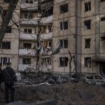 
              Ukrainian policemen look at a heavily damaged building after bombing in Kyiv, Ukraine, Sunday, March 20, 2022. (AP Photo/Felipe Dana)
            