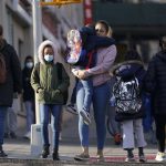 
              Children and their caregivers arrive for school in New York, Monday, March 7, 2022. New York City passed a COVID-19 milestone on Monday as masks became optional in city schools and restaurants and other businesses could stop asking patrons for proof of vaccination. (AP Photo/Seth Wenig)
            