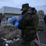 
              A Polish soldier carries a baby of a Ukrainian refugee upon their arrival at the border crossing in Medyka, southeastern Poland, Wednesday, March 2, 2022. Seven days into the war, roughly 874,000 people have fled Ukraine and the U.N. refugee agency warned the number could cross the 1 million mark soon. (AP Photo/Markus Schreiber)
            
