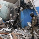 
              Ukrainian serviceman walks past the vertical tail fin of a Russian Su-34 bomber lying in a damaged building in Kharkiv, Ukraine, Tuesday, March 8, 2022. (AP Photo/Andrew Marienko)
            