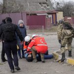 
              Paramedics administer first aid to an elderly man who fainted after crossing the Irpin river to flee the town of Irpin, close to Kyiv, Ukraine, Monday, March 7, 2022. Irpin residents continue to leave the ruined city under Russian heavy artillery shelling. (AP Photo/Efrem Lukatsky)
            