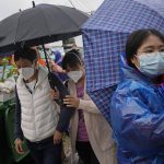 
              Relatives of passengers onboard the China Eastern Flight 5735 arrive near the crash site, Wednesday, March 23, 2022, Lu village, in southwestern China's Guangxi province. The search for clues into why a plane made an inexplicable dive and crashed into a mountain in southern China was suspended Wednesday as rain slicked the debris field and filled the red-dirt gash formed by the plane's fiery impact. (AP Photo/Ng Han Guan)
            