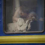 
              A woman sits by the window of a Lviv-bound train, in Kyiv, Ukraine, Thursday, March 3, 2022. Ukrainian President Volodymyr Zelenskyy's office says a second round of talks with Russia aimed at stopping the fighting that has sent more than 1 million people fleeing over Ukraine's borders, has begun in neighboring Belarus, but the two sides appeared to have little common ground. (AP Photo/Vadim Ghirda)
            