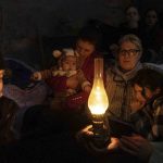 
              People sit around a lamp in a bomb shelter in Mariupol, Ukraine, Sunday, March 6, 2022. (AP Photo/Evgeniy Maloletka)
            