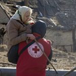 
              A Red Cross worker carries an elderly women during evacuation in Irpin, some 25 km (16 miles) northwest of Kyiv, Friday, March 11, 2022. Kyiv northwest suburbs such as Irpin and Bucha have been enduring Russian shellfire and bombardments for over a week prompting residents to leave their home. (AP Photo/Efrem Lukatsky)
            