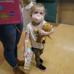 
              Alyssa Carpenter, 3, waits for the elevator with her mother, Tara Carpenter, with stickers and toys given to her during her followup visit to Children's National Hospital in Washington, Monday, Feb. 28, 2022. Alyssa has had COVID-19 twice and suffers long-term symptoms. She is part of a NIH-funded multi-year study at Children's National Hospital to look at impacts of COVID-19 on children's physical health and quality of life. (AP Photo/Carolyn Kaster)
            