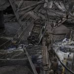 
              Foreign and Ukrainian soldiers cross an improvised path under a destroyed bridge in Irpin, outskirts of Kyiv, Ukraine, Saturday, March 12, 2022. Kyiv northwest suburbs such as Irpin and Bucha have been enduring Russian shellfire and bombardments for over a week prompting residents to leave their homes. (AP Photo/Felipe Dana)
            