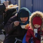 
              A refugee from the Ukrainian city of Mykolaiv, Ekaterina Mosha, 82, has a meal with her grandson Dmitrii, 3, after fleeing the war from neighbouring Ukraine, at the border crossing in Palanca, Moldova, Saturday, March 19, 2022. (AP Photo/Sergei Grits)
            