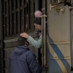 
              A woman holding a child on a Lviv bound train bids goodbye to a man in Kyiv, Ukraine, Saturday, March 12, 2022. Fighting raged in the outskirts of Ukraine's capital, Kyiv, and Russia kept up its bombardment of other resisting cities. (AP Photo/Vadim Ghirda)
            