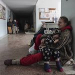 
              Anastasia Erashova cries as she hugs her child in a corridor of a hospital in Mariupol, eastern Ukraine on Friday, March 11, 2022. Anastasia's other child was killed during the shelling of Mariupol. (AP Photo/Evgeniy Maloletka)
            