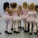 
              Alyssa Carpenter, 2, center, sucks on her fingers during Tiny Tot ballet and tap class at Lyrique Dance in Warrenton, Va., Saturday, Jan. 15, 2022. Alyssa has had COVID-19 twice and suffers long-term symptoms. She had a fever before dance class this morning. She is part of a NIH-funded multi-year study at Children's National Hospital to look at impacts of COVID-19 on children's physical health and quality of life. (AP Photo/Carolyn Kaster)
            