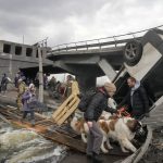 
              People cross an improvised path under a destroyed bridge while fleeing the town of Irpin close to Kyiv, Ukraine, Monday, March 7, 2022. Russia announced yet another cease-fire and a handful of humanitarian corridors to allow civilians to flee Ukraine. Previous such measures have fallen apart and Moscow’s armed forces continued to pummel some Ukrainian cities with rockets Monday. (AP Photo/Efrem Lukatsky)
            