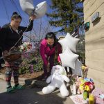 
              Ana DeJesus, right, places a teddy bear on a growing memorial at The Church in Sacramento, Calif., on Tuesday, March 1, 2022. At left, Vera Cruz waits to leave flowers and balloons.  Authorities say a man shot and killed his three daughters, their chaperone and himself during a supervised visit with the girls at the church on Monday. (AP Photo/Rich Pedroncelli)
            