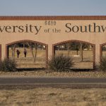 
              People walk through campus at the University of the Southwest, Wednesday, March 16, 2022, in Hobbs, N.M. Students and a golf coach from the school were killed in a head-on collision in West Texas on Tuesday. (AP Photo/John Locher)
            