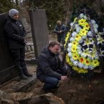 
              Dmytro cries next to the grave of his father Volodymyr Nezhenets, 54, during his funeral in the city of Kyiv, Ukraine, Friday, March 4, 2022. A small group of reservists are burying their comrade, 54-year-old Volodymyr Nezhenets, who was one of three killed on Feb. 26 in an ambush Ukrainian authorities say was caused by Russian 'saboteurs'. (AP Photo/Emilio Morenatti)
            