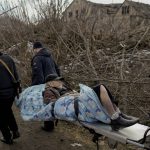 
              People evacuate an elderly man from Irpin, on the outskirts of Kyiv, Ukraine, Wednesday, March 9, 2022. A Russian airstrike devastated a maternity hospital Wednesday in the besieged port city of Mariupol amid growing warnings from the West that Moscow's invasion is about to take a more brutal and indiscriminate turn. (AP Photo/Vadim Ghirda)
            