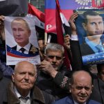 
              People hold portraits of Russian President Vladimir Putin, left, and Syrian President Bashar Assad, right, during a demonstration in support of Russia's invasion of Ukraine, in front of the U.N. headquarters in Beirut, Lebanon, Sunday, March 20, 2022. Dozens of Lebanese, Syrians and Russians gathered to support Putin whose military joined Syria's civil war in 2015 helping tip the balance of power in favor of President Bashar Assad's forces. (AP Photo/Bilal Hussein)
            