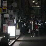 
              People walk on a street during a black out in Tokyo Thursday, March 17, 2022, following an earthquake. A powerful earthquake struck off the coast of Fukushima in northern Japan on Wednesday evening, triggering a tsunami advisory and plunging more than 2 million homes in the Tokyo area into darkness. (Kyodo News via AP)
            