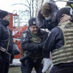 
              Policemen help a woman who was evacuated by firefighters from a destroyed apartment building after a bombing in a residential area in Kyiv, Ukraine, Tuesday, March 15, 2022. Russia's offensive in Ukraine has edged closer to central Kyiv with a series of strikes hitting a residential neighborhood as the leaders of three European Union member countries planned a visit to Ukraine's embattled capital. (AP Photo/Vadim Ghirda)
            