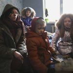 
              A woman and her children speak to journalists sitting in their flat without electricity on the territory which is under the Government of the Donetsk People's Republic control, on the outskirts of Mariupol, Ukraine, Thursday, March 24, 2022. (AP Photo/Alexei Alexandrov)
            