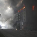 
              Firefighters hose down a burning building after bombing in Kyiv, Ukraine, Thursday, March 3, 2022. Russian forces have seized a strategic Ukrainian seaport and besieged another. Those moves are part of efforts to cut the country off from its coastline even as Moscow said Thursday it was ready for talks to end the fighting. (AP Photo/Efrem Lukatsky)
            