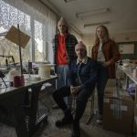 
              Ukrainian co-founders of high-end hat designer brand Ruslan Baginskiy 'RB', from left, public relations director Petro Yasinskiy, designer and creative director Ruslan Baginskiy and Victoria Semerei, whole sale director, pose for a photograph, inside a college classroom turned into a workshop they have been working from after fleeing Kiev, in Lviv, western Ukraine, Friday, March 25, 2022. Daily bombings led the company's co-founders to make the decision to flee. (AP Photo/Nariman El-Mofty)
            