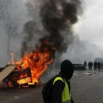 
              FILE - A barricade burns on the Champs Elysees avenue during a Yellow Vests demonstration, Saturday, March 16, 2019 in Paris. The Yellow Vest movement started in October 2018 among provincial workers camped out at traffic circles to protest a hike in fuel taxes, sporting the high-visibility vests all French drivers must keep in their cars for emergencies. It quickly spread to people across political, regional, social and generational divides angry at economic injustice and the way Macron was running France. French President Emmanuel Macron has formally announced that he will seek a second term in April’s presidential election. (AP Photo/Christophe Ena, File)
            