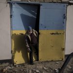 
              A man tries to open a door damaged after a Russian bombing in Baryshivka, east of Kyiv, Ukraine, Friday, March 11, 2022. (AP Photo/Felipe Dana)
            