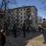 
              Policemen stand guard at the site where a bombing damaged residential buildings in Kyiv, Ukraine, Friday, March 18, 2022. Russian forces pressed their assault on Ukrainian cities Friday, with new missile strikes and shelling on the edges of the capital Kyiv and the western city of Lviv, as world leaders pushed for an investigation of the Kremlin's repeated attacks on civilian targets, including schools, hospitals and residential areas. (AP Photo/Rodrigo Abd)
            