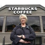 
              Pam Blauman-Schmitz, who was a union rep at Starbucks in the mid-1980's, poses for a photo in front of a Starbucks coffee shop Tuesday, Feb. 22, 2022, in Seattle. Starbucks, now facing union elections at more than 100 U.S. stores, has spent decades fighting unionization. (AP Photo/Elaine Thompson)
            