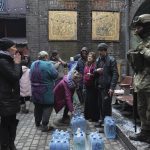 
              Ukrainian servicemen, right, distributes water to people in Mariupol, Ukraine, Sunday, March 6, 2022. (AP Photo/Evgeniy Maloletka)
            